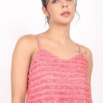 Portrait of model showing shoulder straps and upper bodice of coral cotton nightie.