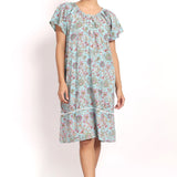 Front view Model wearing aqua floral cotton nightie with cap sleeves and mid-length hem.