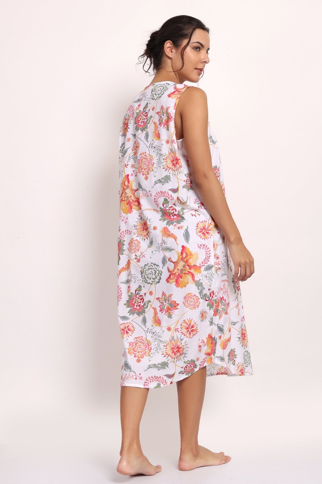 Back view of Model turns slightly, showing coral botanical pattern and relaxed silhouette.
