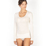 Woman wearing ivory wool and silk long sleeve top by EGI, with scoop neck and ribbed texture.