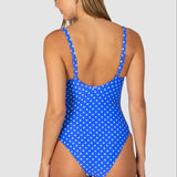 Woman wearing a blue polka dot swimsuit on a white background back view