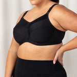 Side profile of Triaction Ultra Sports Bra Black, highlighting double-layer cups and padded straps