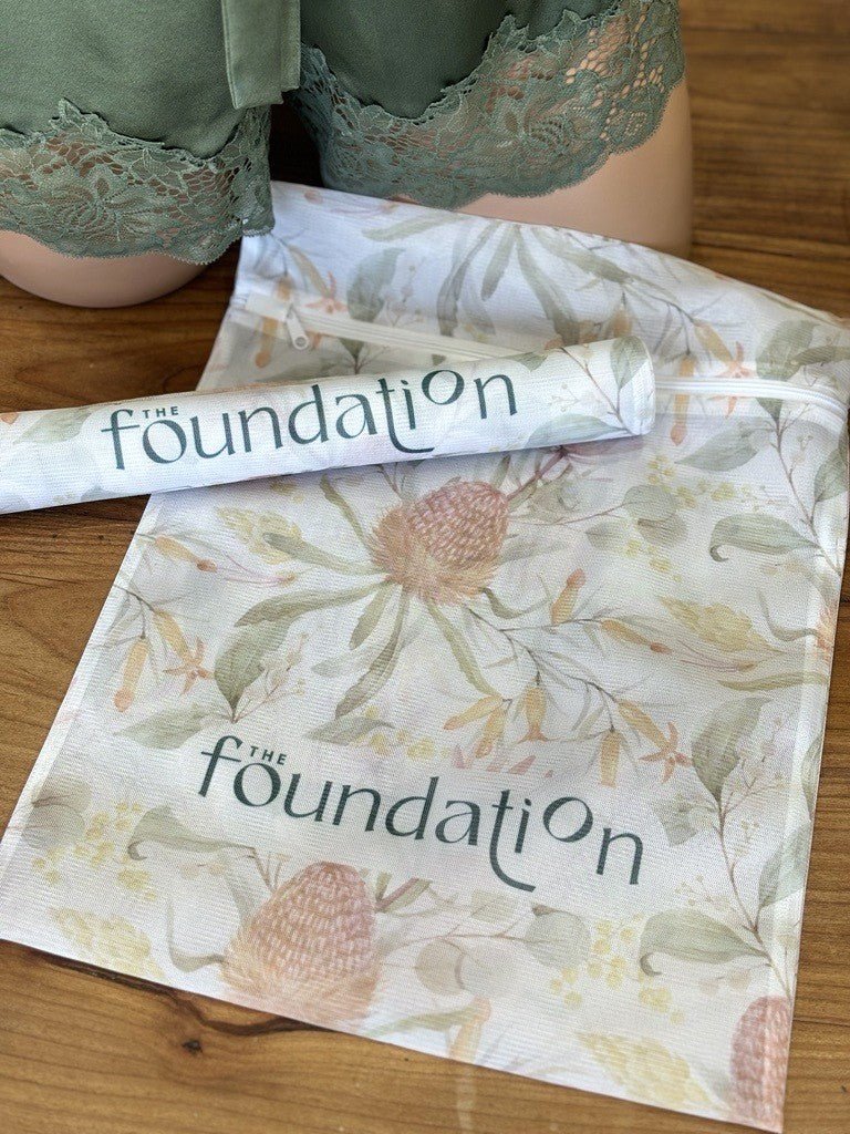 The Foundation Wash Bag shown with lingerie, featuring mesh fabric and Australian Botanical Print design.