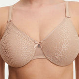 Model in Chantelle C Magnifique Moulded Bra in Nude from The Foundation, featuring seamless full cups, minimising support, and soft mesh band. close up view
