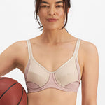 Woman wearing the Electrify Mesh Underwire Sports Bra in Soft Powder, front view with sports styling, available at The Foundation.
