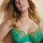 Model in Lenca Balcony Bra Sunny Teal from The Foundation, smiling to highlight airy design and detailed floral embroidery