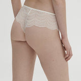 Model wearing Simone Pérèle Karma Shorty Brief in Natural from The Foundation, mid-rise lace design with cheeky back and scalloped edge detail. back view