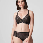 Model wearing Vya thong and matching plunge bra, styled as a striking black lingerie set.
