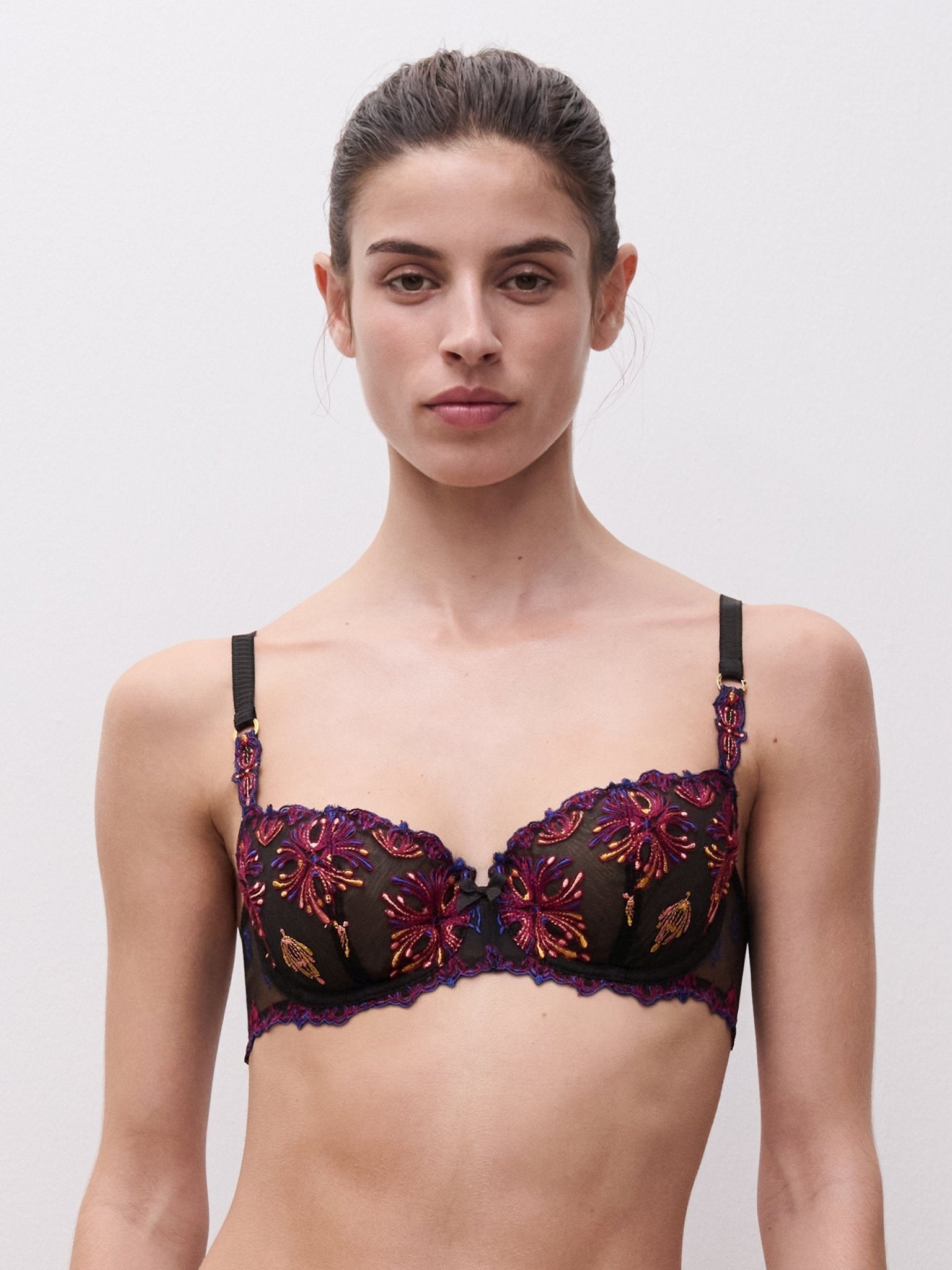 Chantelle half cup balcony bra in black with colourful floral embroidery, featuring adjustable straps and structured cups for support
