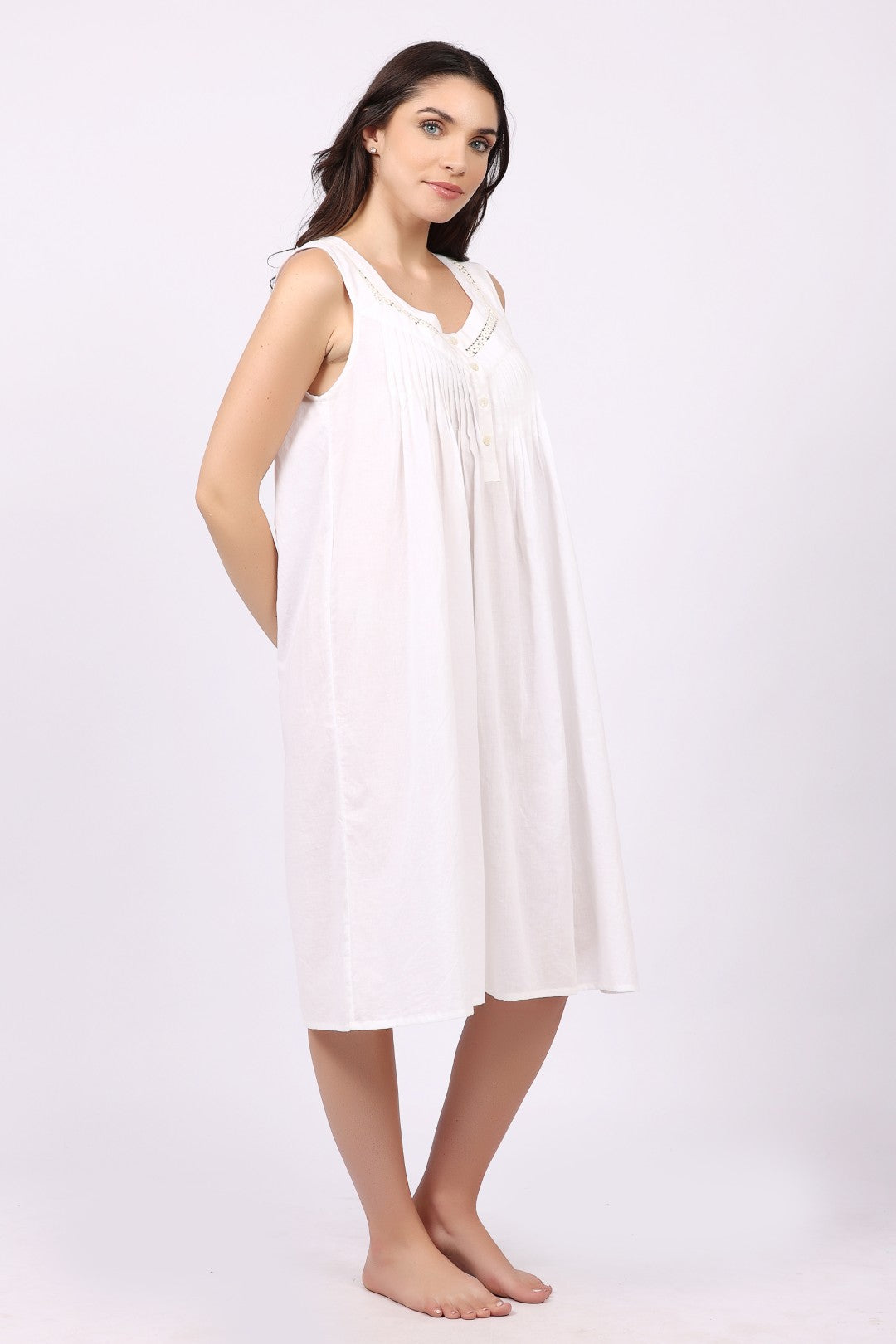 Woman wearing a white sleeveless cotton nightdress from Lotus sleepwear, featuring a relaxed fit and lightweight breathable fabric ideal for warm nights