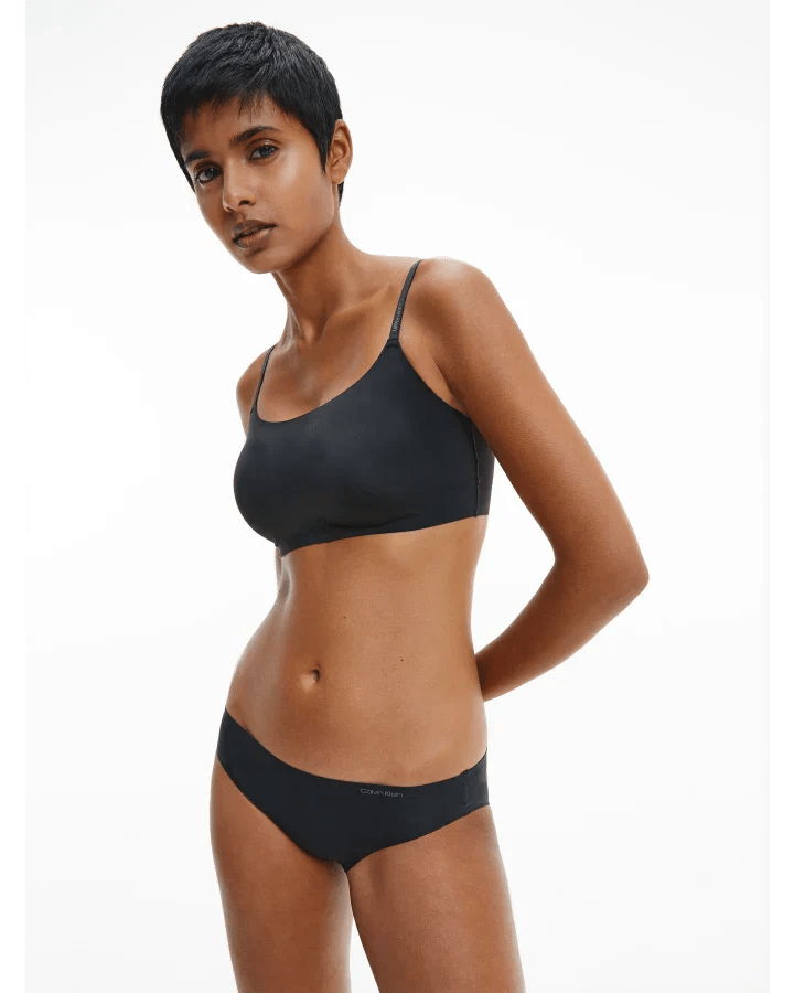Woman wearing Calvin Klein Invisibles Comfort Lightly Lined Bralette in black, showcasing seamless, wireless fit.