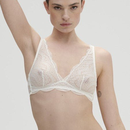 Model wearing the Karma Wireless Triangle Bra in Natural — a soft, wirefree lace bra offering breathable comfort and effortless everyday support.