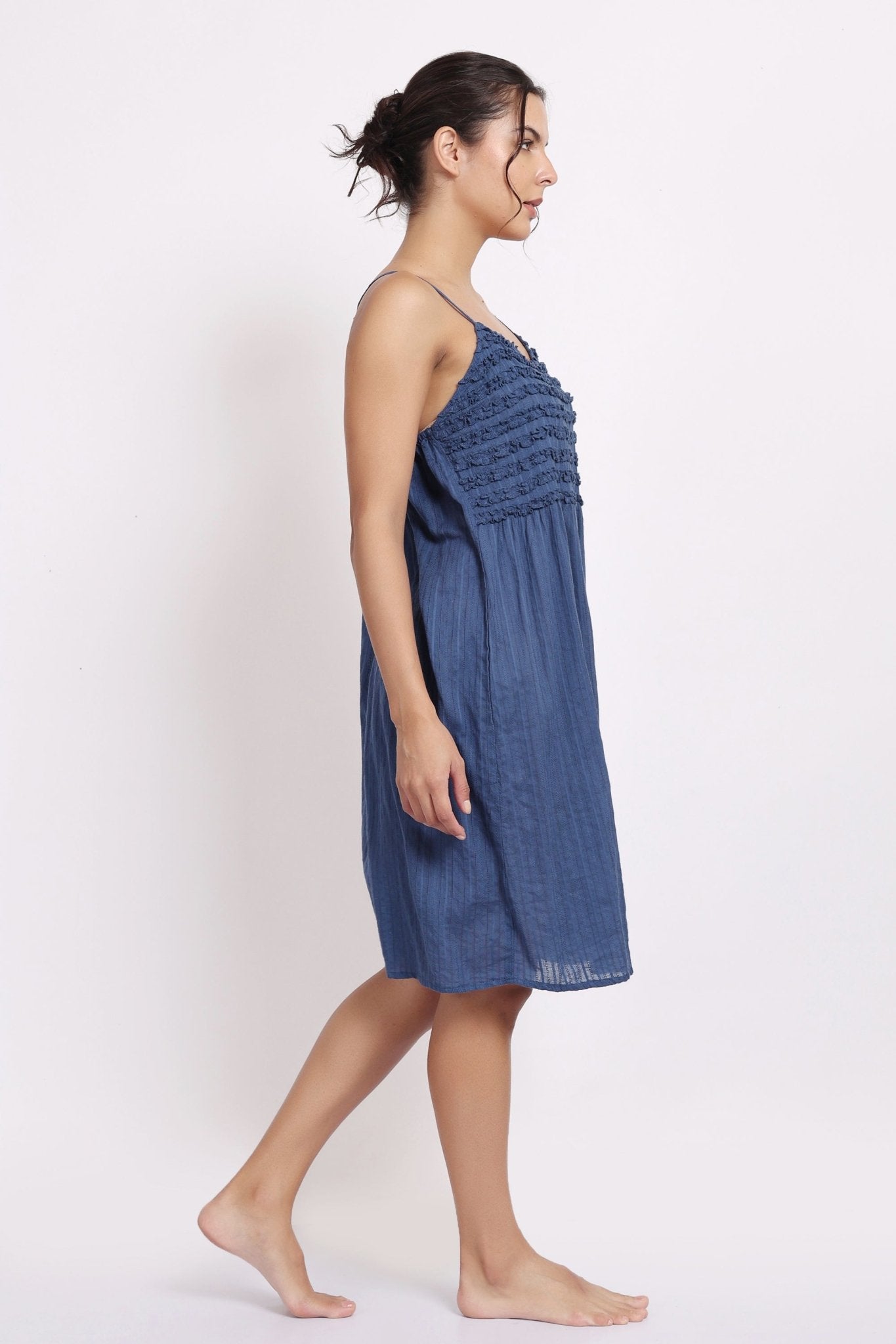 Side profile of model in navy frilly nightie, showing light drape and midi length.