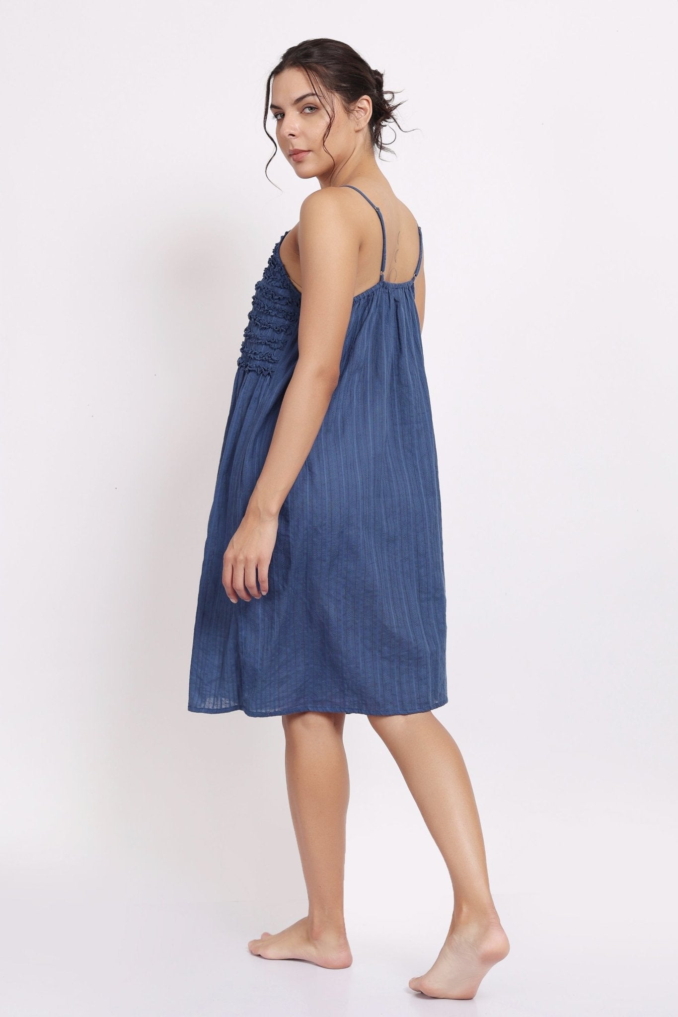 Back view of navy cotton nightie with adjustable straps and gathered fabric.