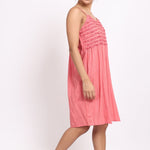 Angled side profile of coral cotton nightie highlighting light drape and relaxed fit.