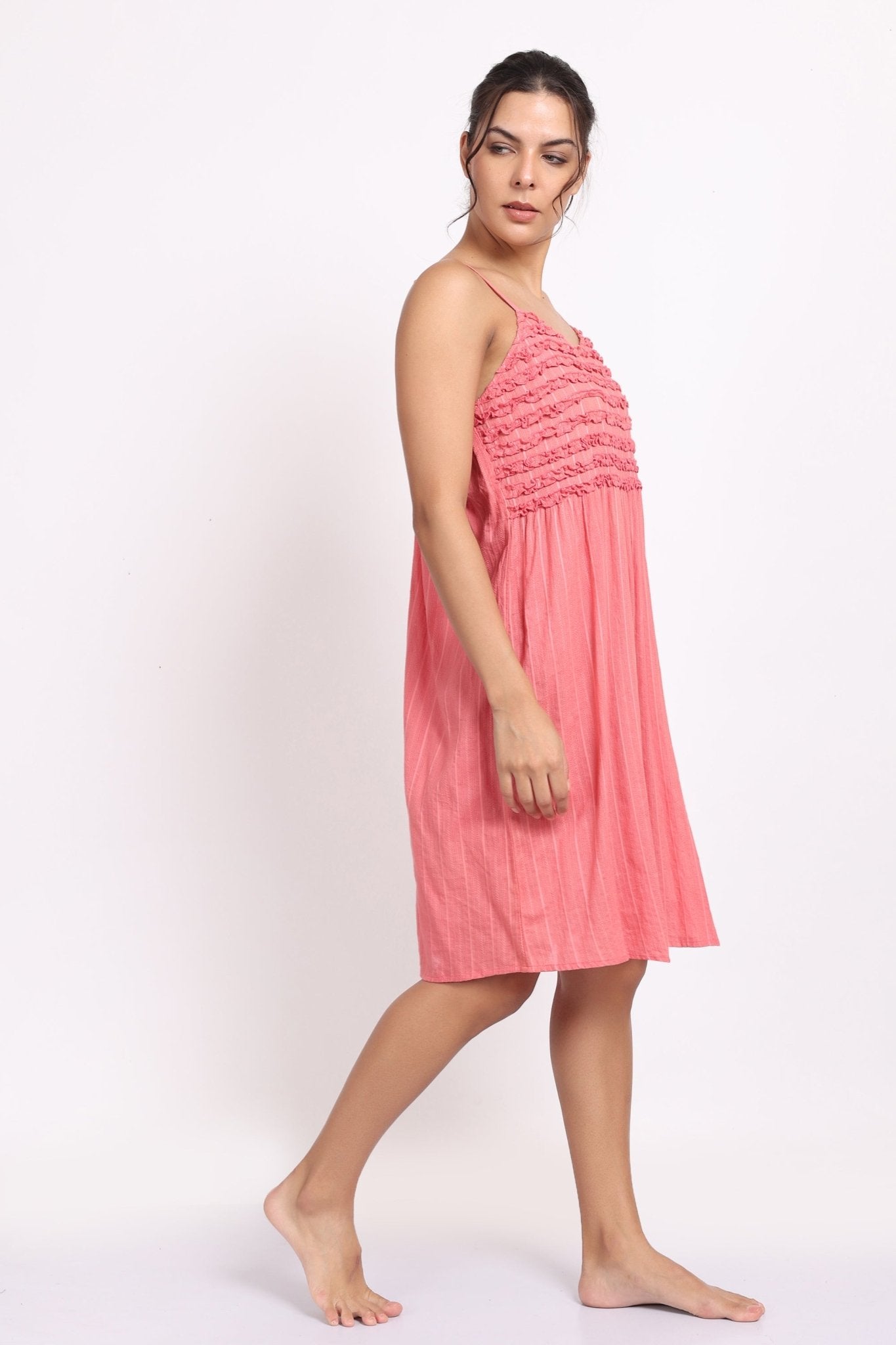 Angled side profile of coral cotton nightie highlighting light drape and relaxed fit.