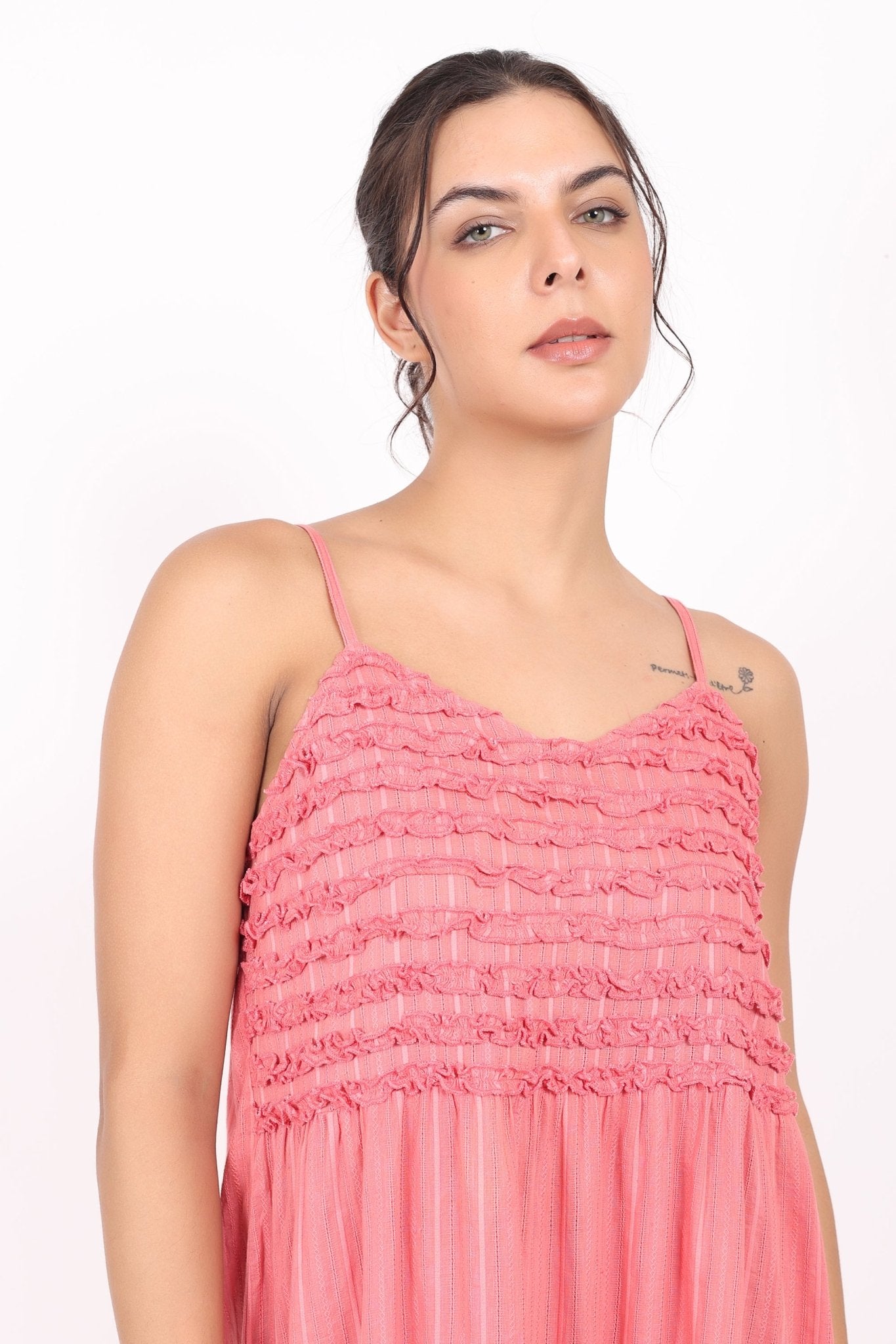 Portrait of model showing shoulder straps and upper bodice of coral cotton nightie.
