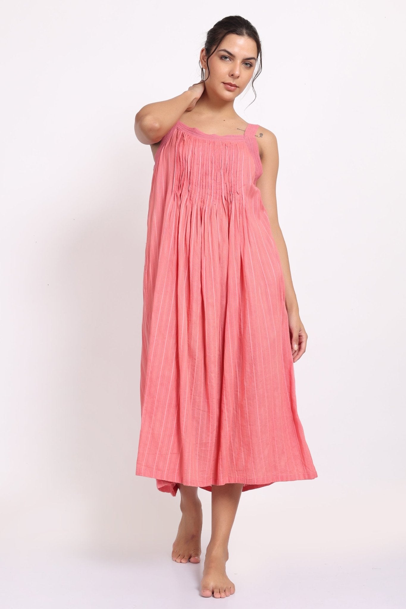 Model wearing coral cotton strappy nightie with subtle self-stripe, front view with raised arm.