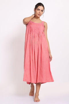 Model wearing coral cotton strappy nightie with subtle self-stripe, front view with raised arm.