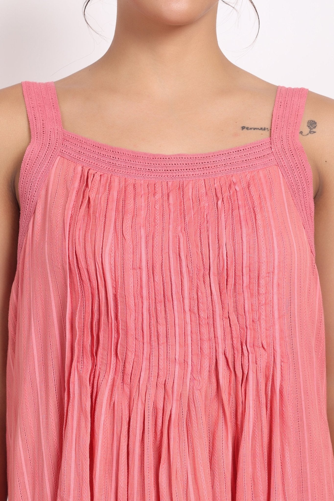 Detail of square neckline with soft crochet straps on coral striped cotton.
