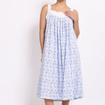 Front view of Model wearing white cotton nightie with navy floral print, crochet straps, and pintuck pleats.