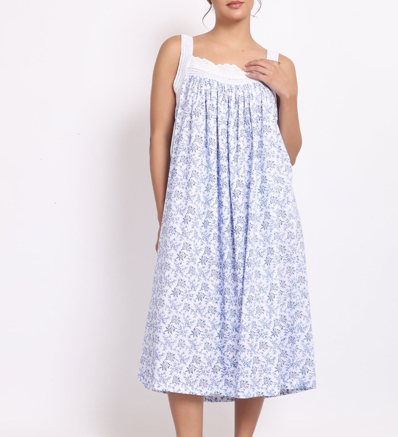 Front view of Model wearing white cotton nightie with navy floral print, crochet straps, and pintuck pleats.