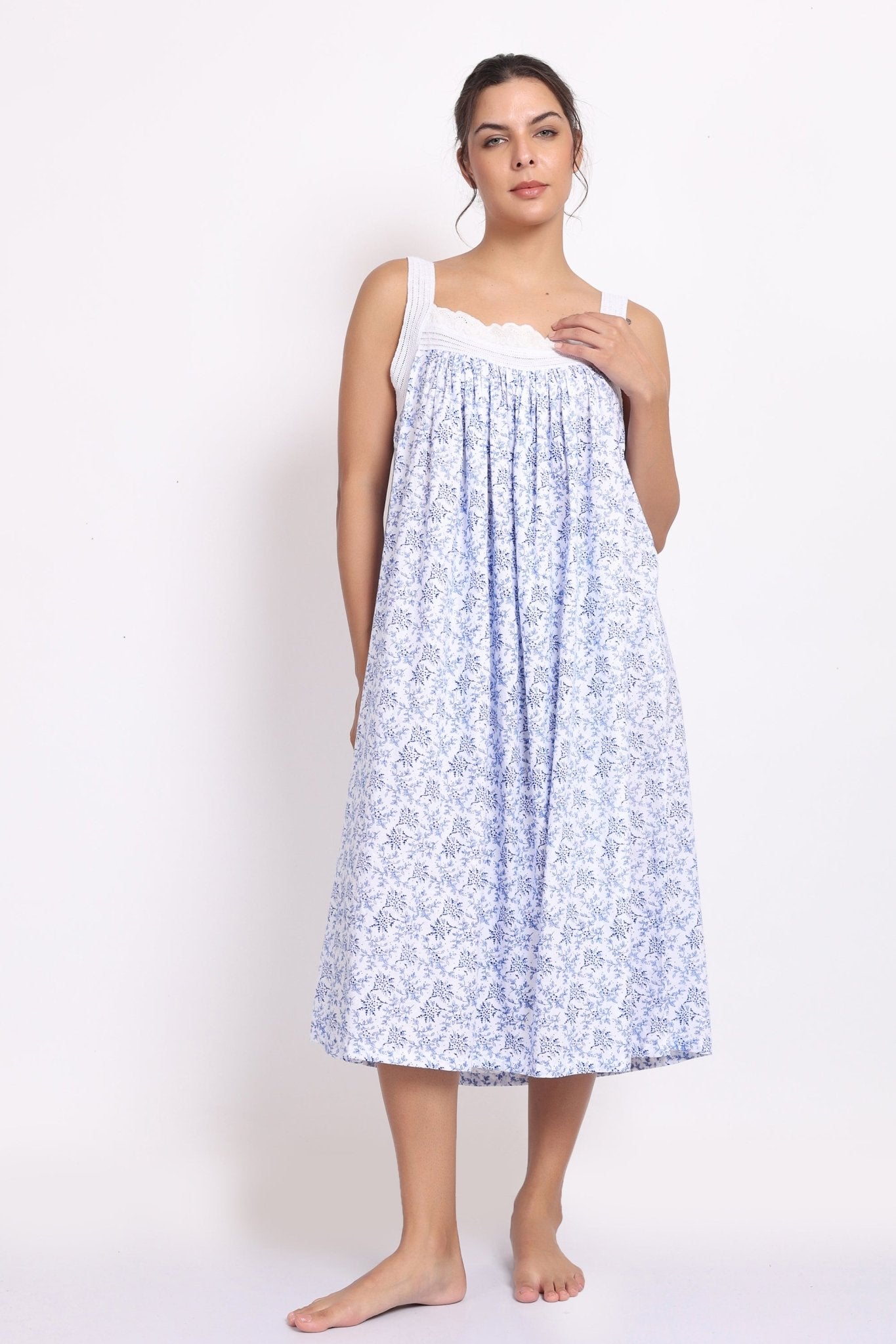 Front view of Model wearing white cotton nightie with navy floral print, crochet straps, and pintuck pleats.