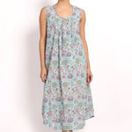 Model wearing Bloom Sleeveless Nightie in aqua floral print, mid-calf length with scooped hem and gathered neckline.