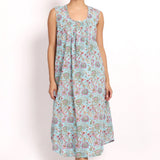Model wearing Bloom Sleeveless Nightie in aqua floral print, mid-calf length with scooped hem and gathered neckline.
