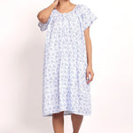 Model wearing cap sleeve cotton nightie in white with navy floral print.