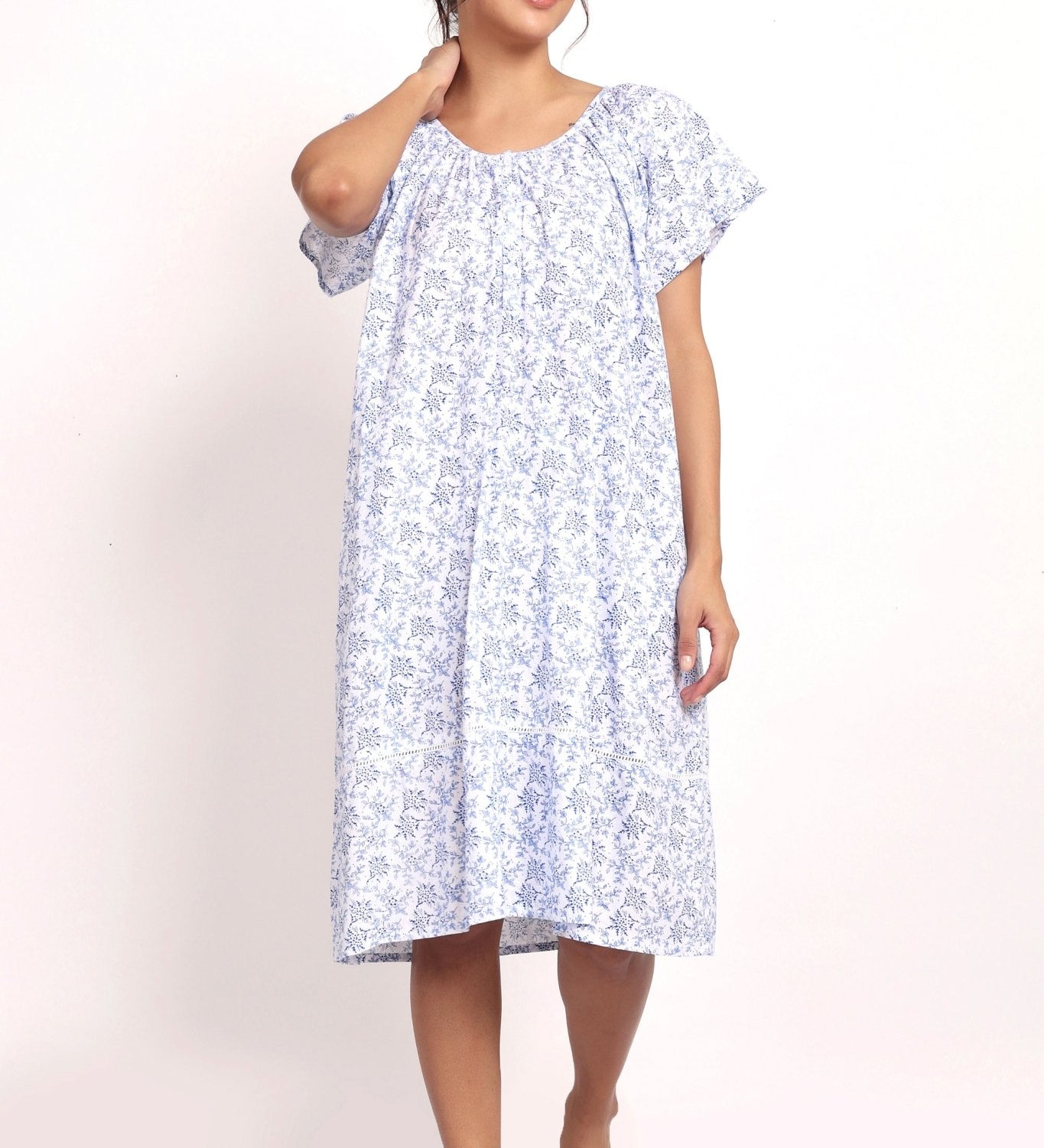 Model wearing cap sleeve cotton nightie in white with navy floral print.