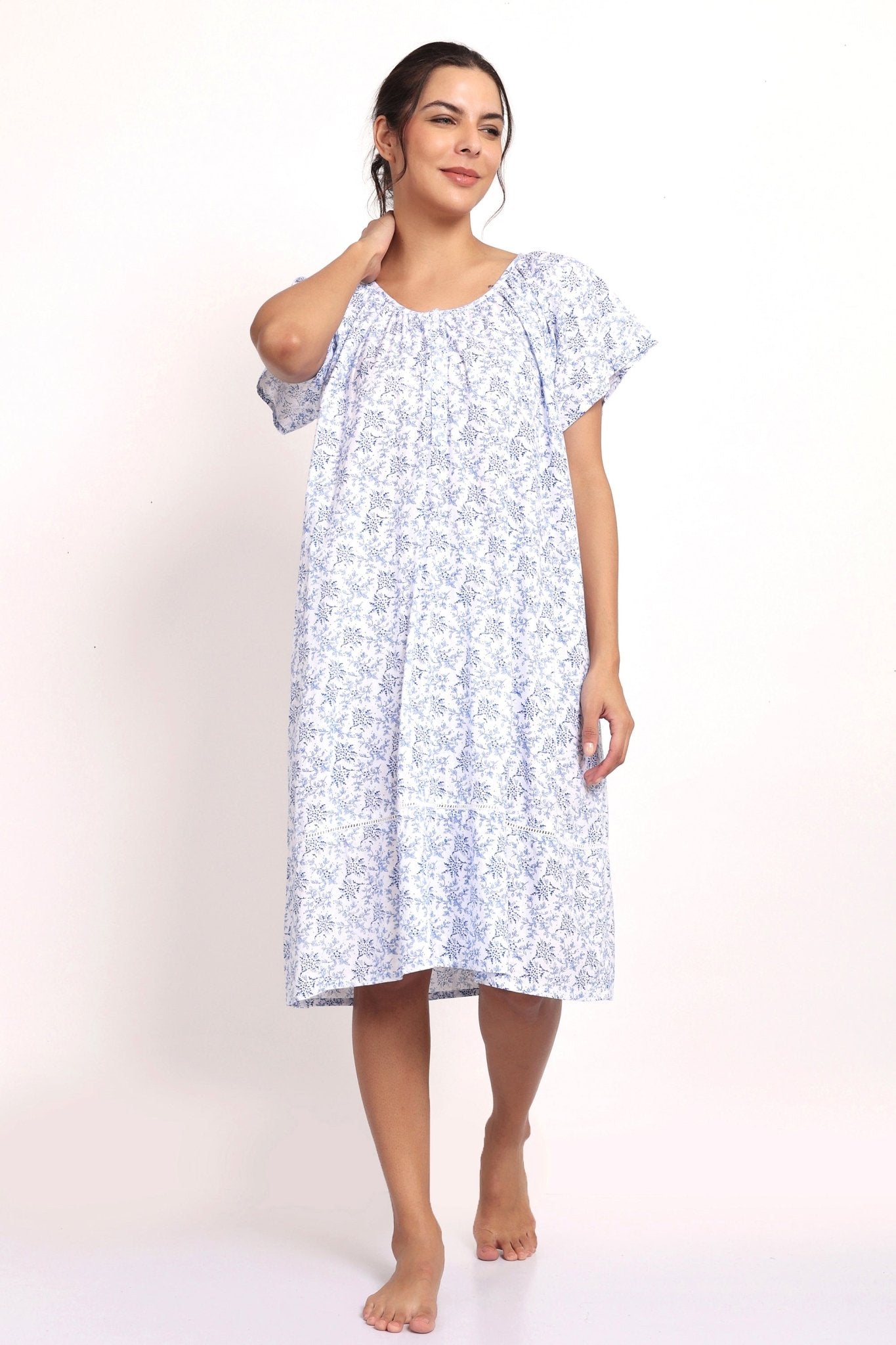 Model wearing cap sleeve cotton nightie in white with navy floral print.