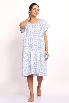 Model wearing cap sleeve cotton nightie in white with navy floral print.