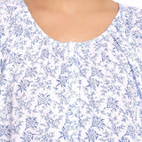 Detail view of round neckline with soft pleating and floral pattern.