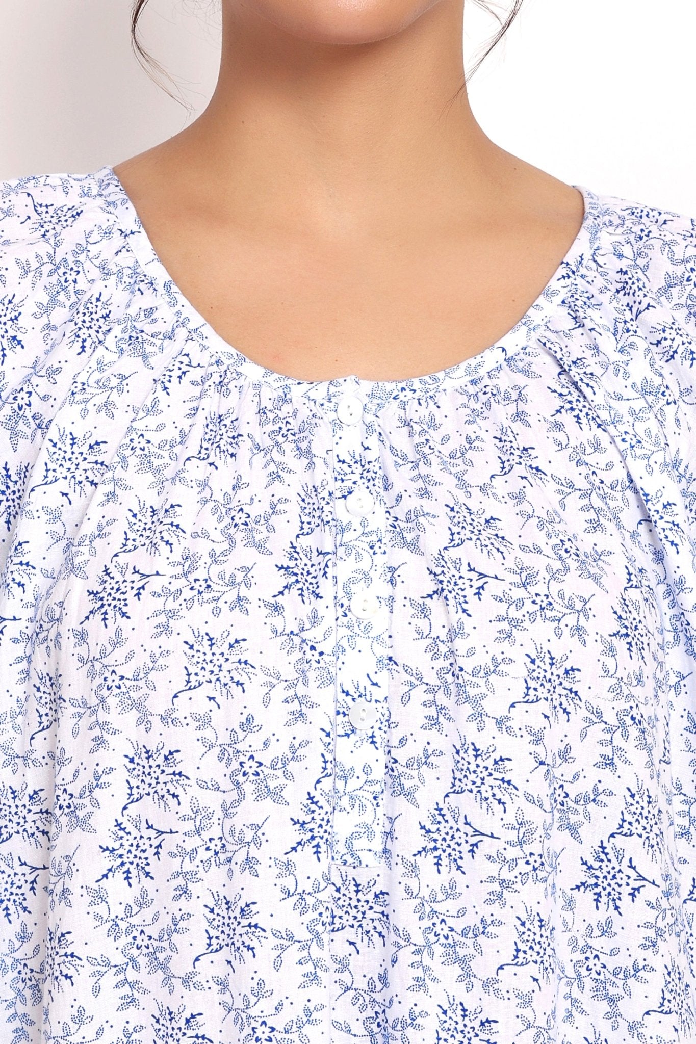 Detail view of round neckline with soft pleating and floral pattern.