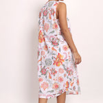 Back view of Model turns slightly, showing coral botanical pattern and relaxed silhouette.