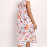 Back view of Model turns slightly, showing coral botanical pattern and relaxed silhouette.
