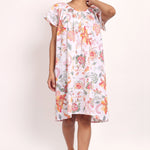 Model in peach botanical print cotton nightie with cap sleeves and knee-length cut.