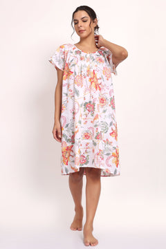 Model in peach botanical print cotton nightie with cap sleeves and knee-length cut.