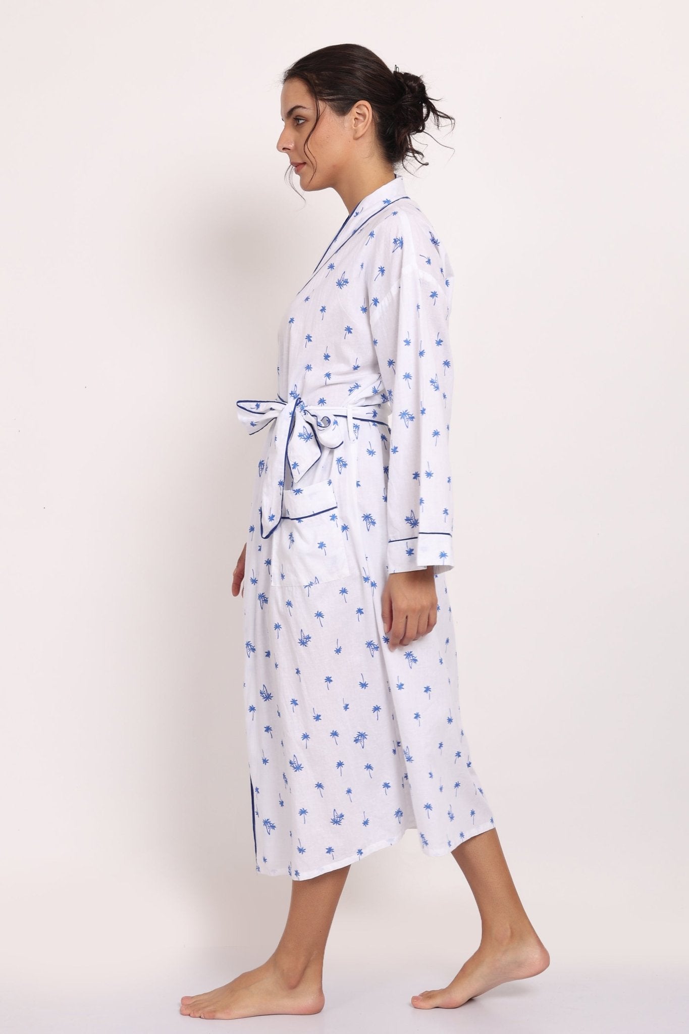 Side profile of model walking in the Hamptons navy palm print cotton robe.