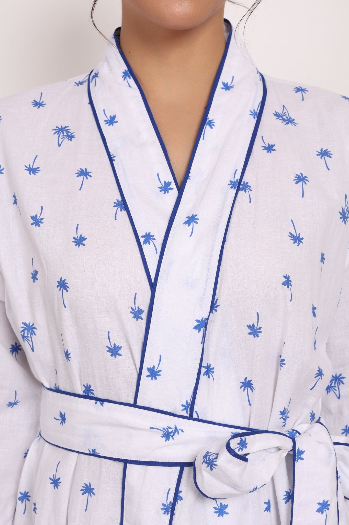 Zoomed view of white cotton voile with navy piping and micro palm print.