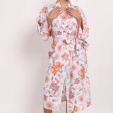 Model wearing Passionflower Kimono in coral print, featuring wide lapels, tie belt and relaxed cotton fit.