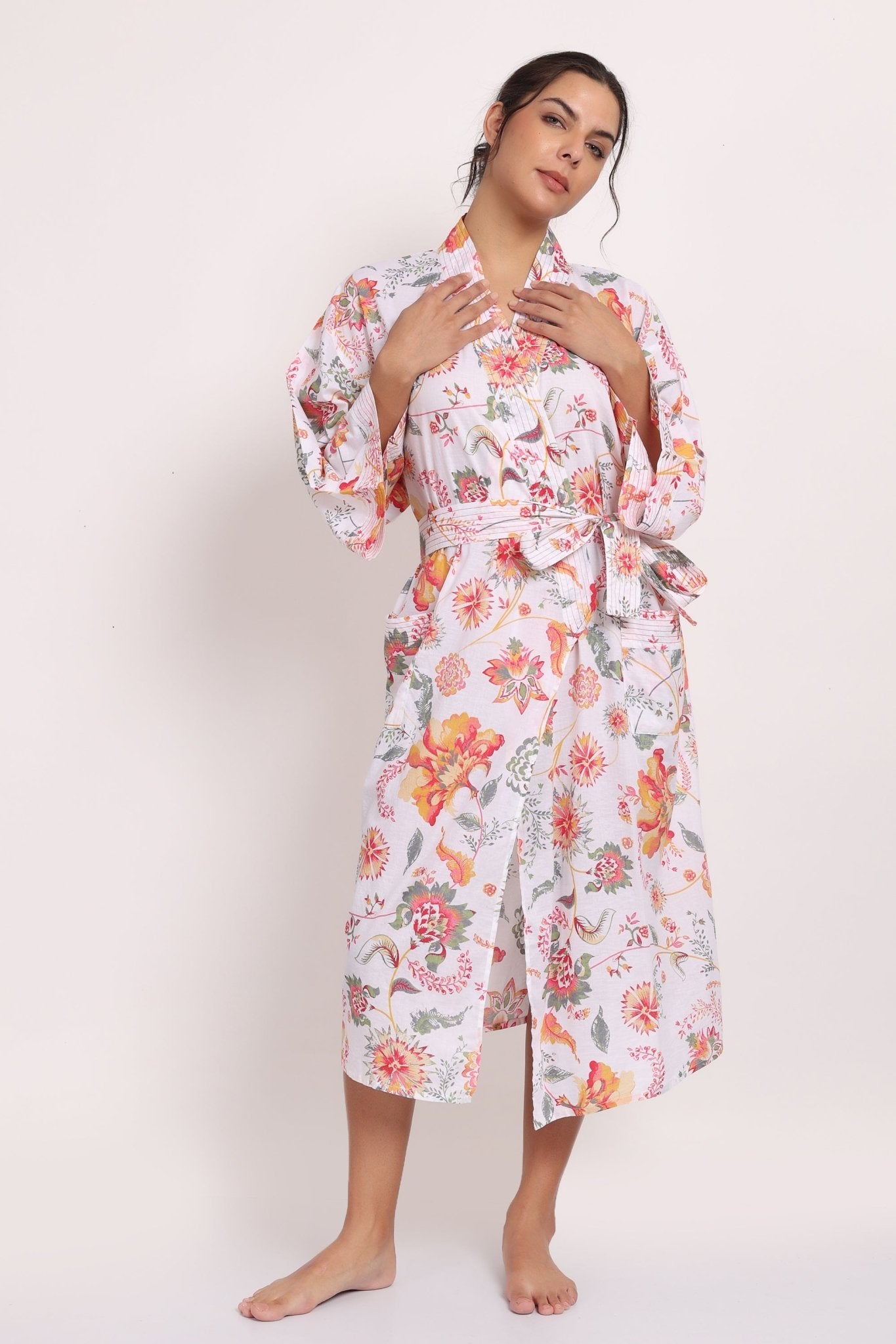 Model wearing Passionflower Kimono in coral print, featuring wide lapels, tie belt and relaxed cotton fit.