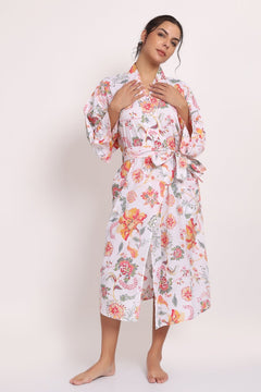 Model wearing Passionflower Kimono in coral print, featuring wide lapels, tie belt and relaxed cotton fit.