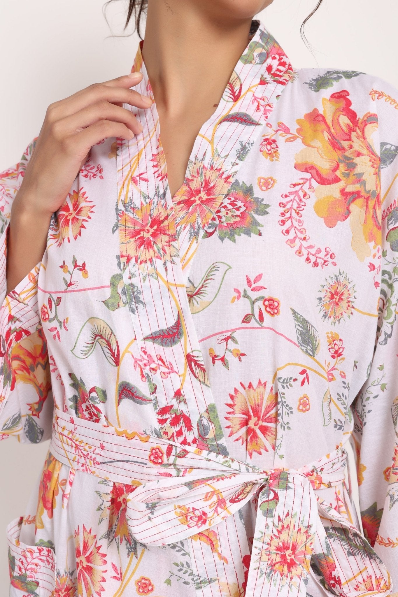 Side close-up of Passionflower Coral Kimono, showcasing stitching along the sleeve and kimono-style structure.