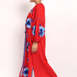 Side view of red cotton sundress showing sleeve details and embroidered floral pattern.