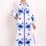 Model standing in Romani white and navy embroidered sundress, showing full front design.