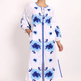 Model standing in Romani white and navy embroidered sundress, showing full front design.
