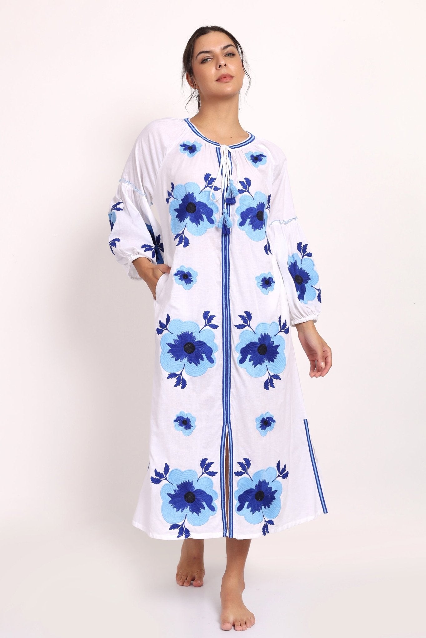 Model standing in Romani white and navy embroidered sundress, showing full front design.