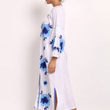 Side view of embroidered white cotton sundress showing flowy drape and hemline.